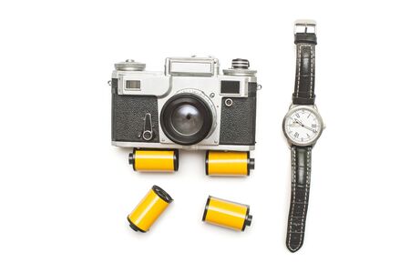 Creative retro concept from the past. Old retro film camera and photo film roll with mechanical men's watch isolated on white background. Flat lay, top viewの写真素材