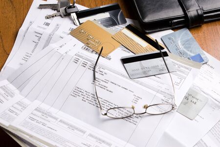 The credits cards and the bills on the table. The number and personal ID of the credit card has been removed or replaced from the original one to prevent unnecessary things.の写真素材