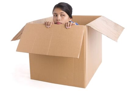 A young woman looks depressed inside the box.の写真素材