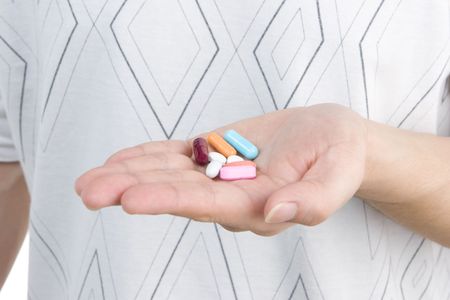 A man's hand is holding variation of medicines.の写真素材