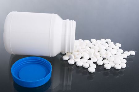A lot of vitamin tablets are spilled on the tablet.の写真素材