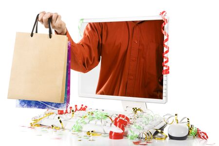 A man is holding paper bags from inside computer's screen. Confetti scattered around the computer.の写真素材