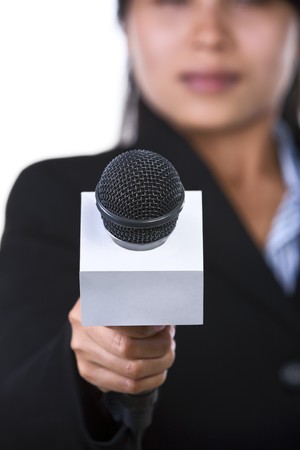 A woman is holding a microphone to the camera. Shot against white background.の写真素材
