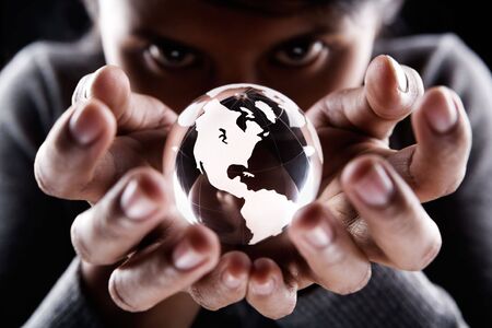A woman holding a glass globe with mysterious looking, showing America continentの写真素材