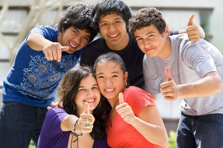 Multi ethnic teenagers posing outside school buildingの写真素材