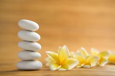Zen stone and frangipani flower on bamboo matの写真素材