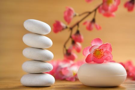 Zen stone, aromatic soap bar with red flower on bamboo matの写真素材