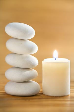 Zen stone and candle on bamboo matの写真素材