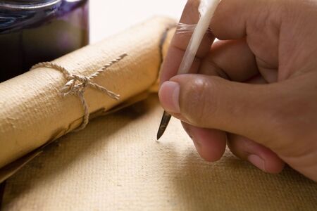 Hand writing on old parchment / paper using quill penの写真素材