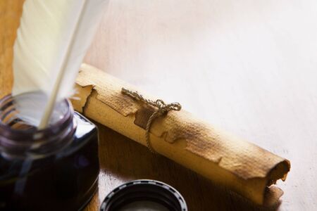 Scroll and quill pen on wooden tableの写真素材