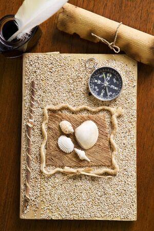 Old journal book, scroll and quill pen on wooden tableの写真素材