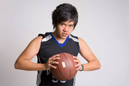 Basketball player holding ball while gazing to cameraの写真素材
