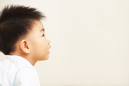 Asian toddler with copy space looking away to wish or hope somethingの写真素材