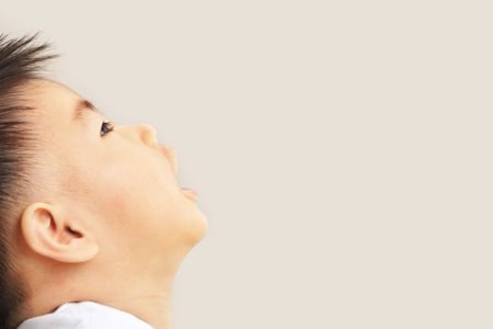 Asian toddler with copy space looking away to wish or hope somethingの写真素材