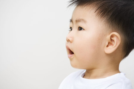 Asian toddler with copy space looking away to wish or hope somethingの写真素材