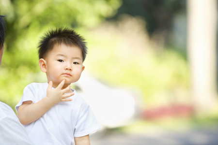Asian toddler thinking in outdoor area with enough copy spaceの写真素材