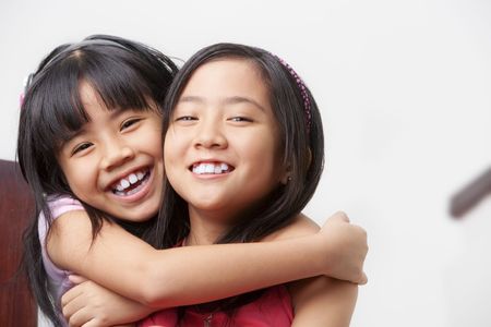 two little girl showing their affection posing to cameraの写真素材