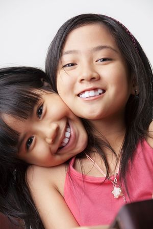 two little girl showing their affection posing to cameraの写真素材