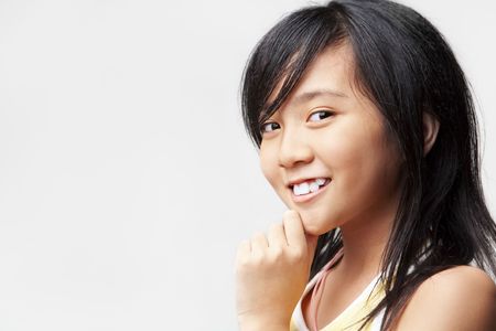 LIttle Asian girl posing to camera over white backgroundの写真素材