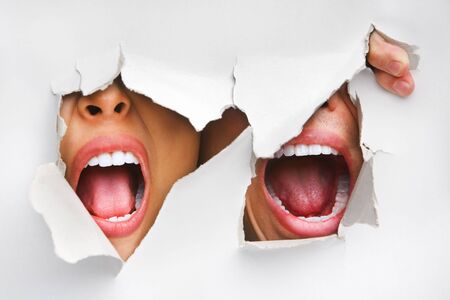 Two mouths screaming from hole in wallの写真素材