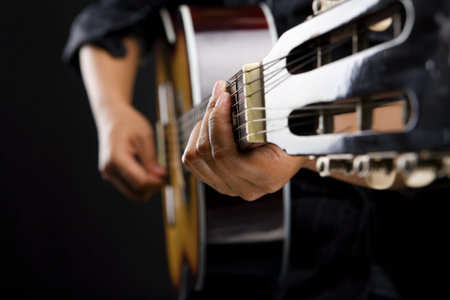 close up people playing classic guitar on dark room