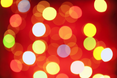 Blurred christmas lamp arranged on red background