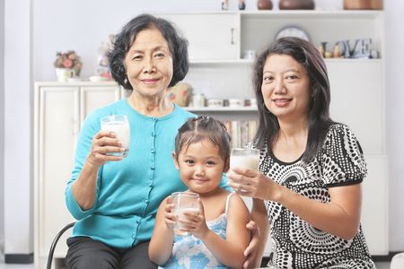 Three Asian female generation holding a glass of milkの写真素材