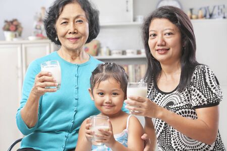 Three Asian female generation holding a glass of milkの写真素材