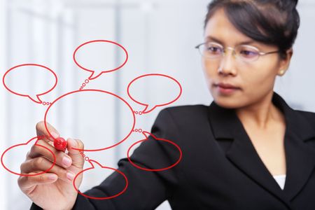 Asian businesswoman writing or drawing a diagram on glass board.  PS : focus on the felt tip penの写真素材