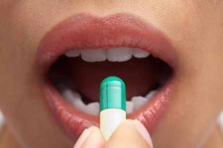 Woman mouth and capsule for health and medication conceptの写真素材