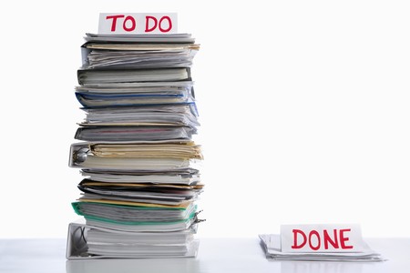 To do and done paperwork in unbalance proportion, against white backgroundの写真素材