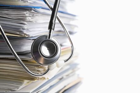 Medical record concept with stetoschope over pile of document. Selective focus on the front side of the stethoscopeの写真素材