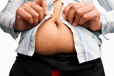 female hand trying hard to button thes shirt with overwight issue