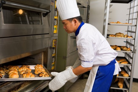 Baker holding the sweet bread fresh from the ovenの写真素材