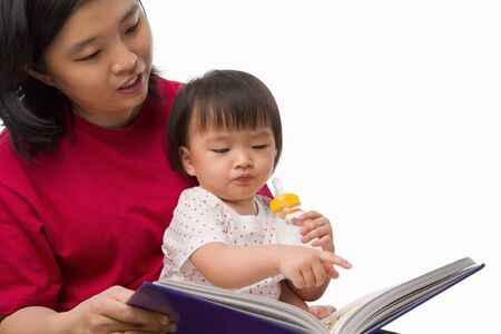 Chinese young woman story telling her cute daughterの写真素材