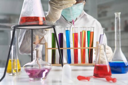 Scientist doing experiment in laboratory with lot of equipment and chemical solutionの写真素材