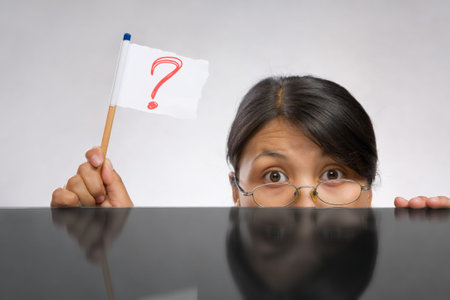 Woman holding question mark flag made of paper and pencil