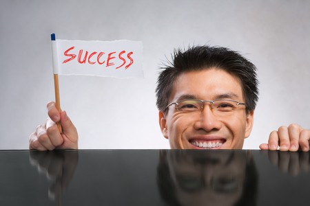 Happy man holding success flag made of paper and pencil