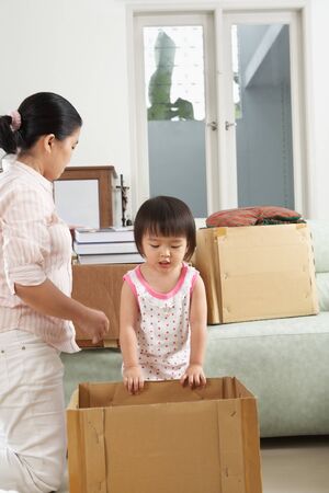 Mother and daugher packing items for moving houseの写真素材