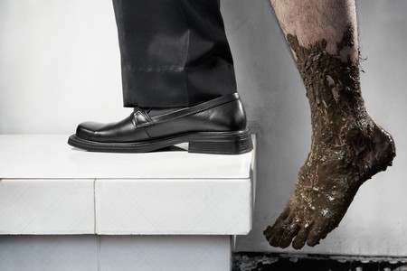 Success concept from poor to be rich, one leg step from below with full of mud and the other leg using business attire. Legs of one person, without compositingの写真素材