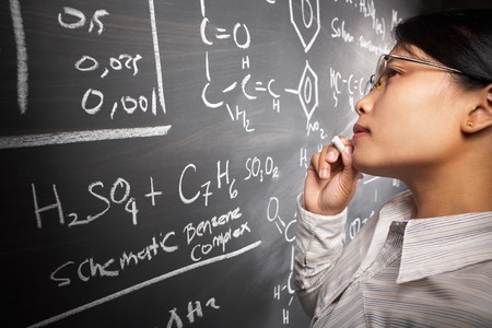 Female student working on difficult equation on blankboardの写真素材