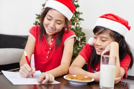 Kids busy preparing letter to Santa for their wishesの写真素材