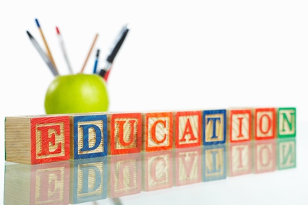Word 'Education' arranged in front a green apple and set of pensil and pensの写真素材