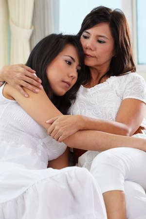 Mother consoling her sad daughter who has problemの写真素材