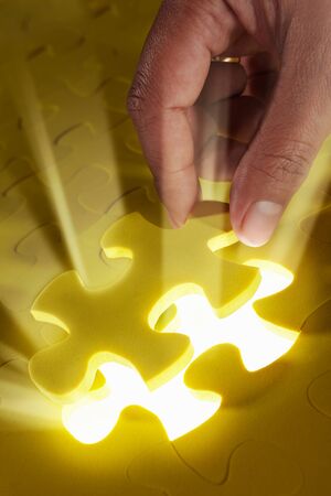 Concept photo using piece of puzzle with ray of light comes out from missing pieceの写真素材