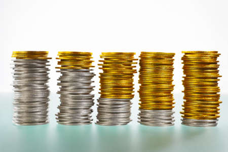 Five stacks of coins consisiting silver and goldens onesの写真素材
