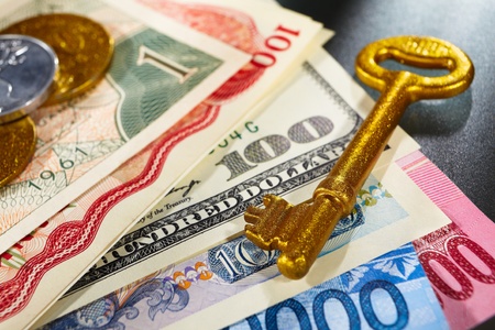 Golden key over money from different countriesの写真素材