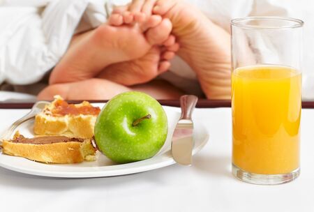 Intimate couple spending their time in bed and breakfast near their feetの写真素材