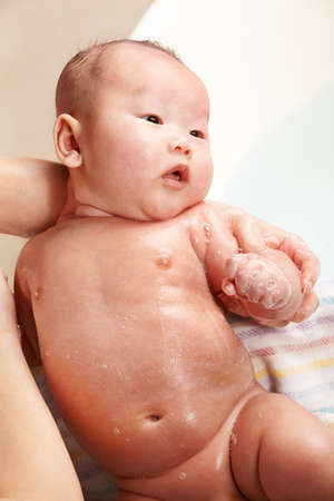 Chinese baby boy being bathed by his mom.の写真素材