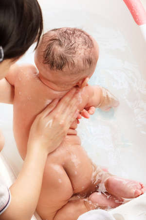 Chinese baby boy being bathed by his mom.の写真素材